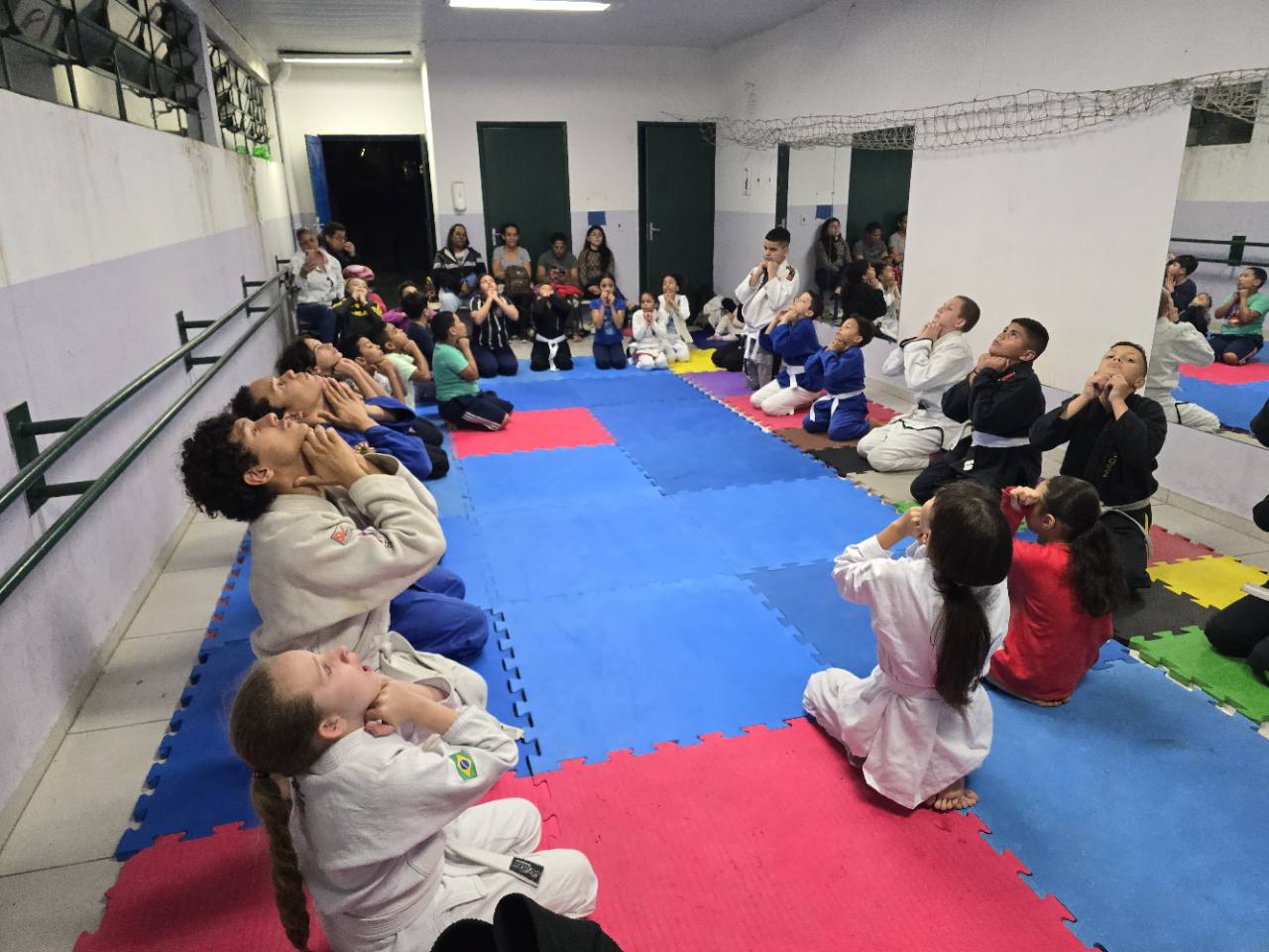Alunos do Projeto Mão com Mão participando de uma atividade coletiva no tatame